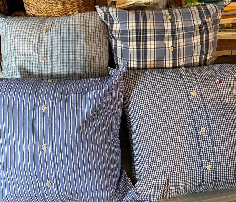Four 16x16 inch memory pillows made from customer's shirts. They are blue with stripe and plaid designs.