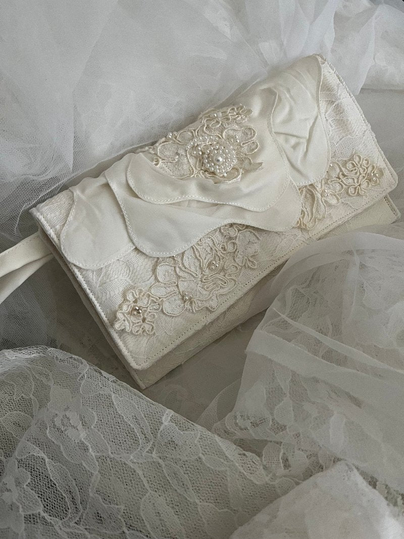 Ivory wedding clutch made from wedding dress with large flower on the flap and applique and sequins. Measures 8x5 and has side strap.