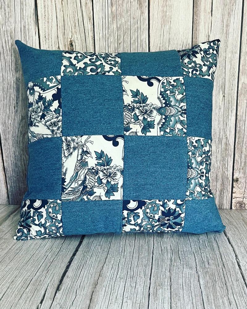 16x16 patchwork keepsake pillow. The patchwork has 16 blocks alternating with plain denim and blue and white paisley. the pillow is made from a customer's clothes.